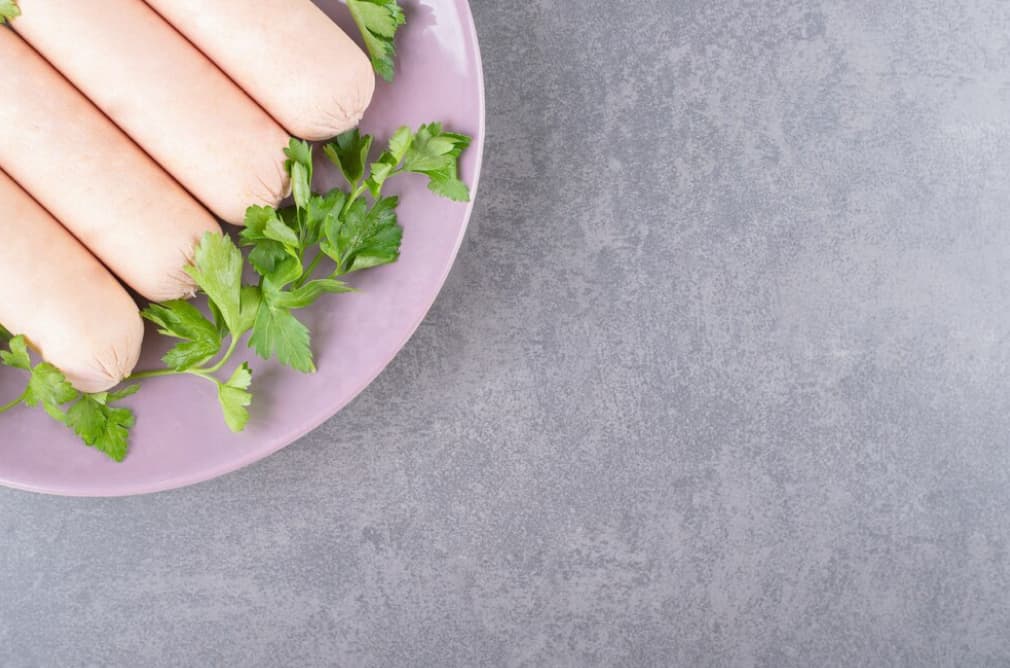 sausages on a purple plate garnished with parsley