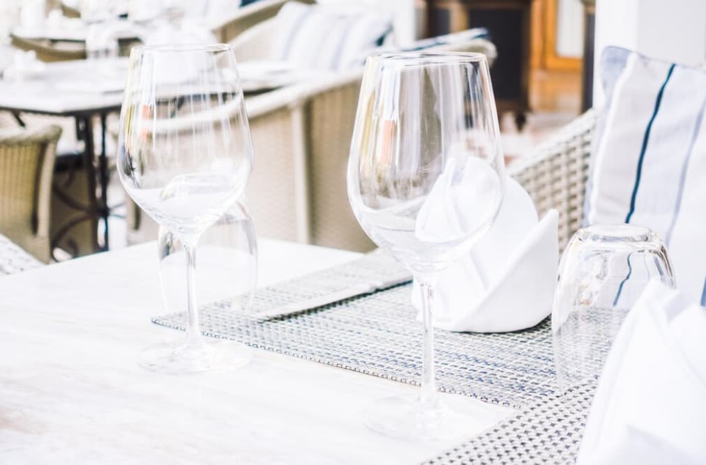 Elegant outdoor table with wine glasses and wicker chairs