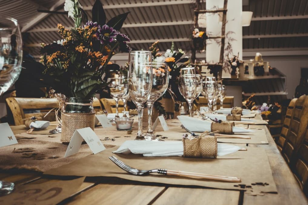 Rustic table setting for an event with burlap-wrapped cutlery