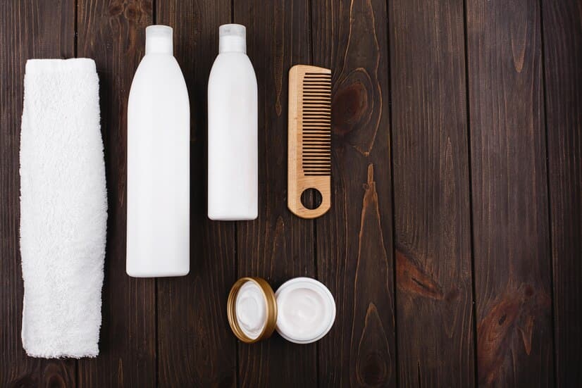 Bottles of Shampoo and Conditioner on Wooden Table